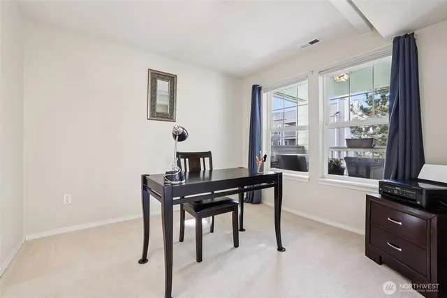 a view of a workspace with furniture and a window
