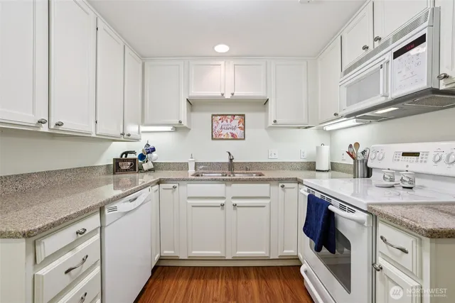 a kitchen with cabinets appliances a sink and a counter top space