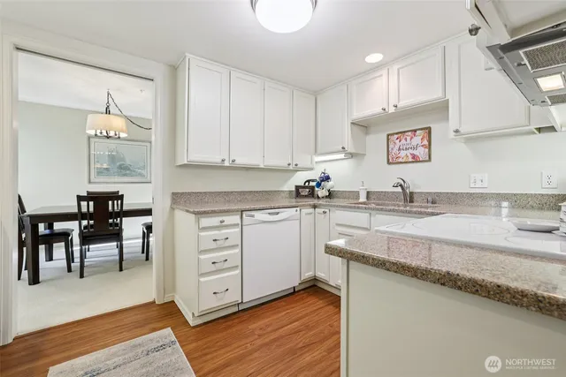 a kitchen with granite countertop a sink cabinets and wooden floor