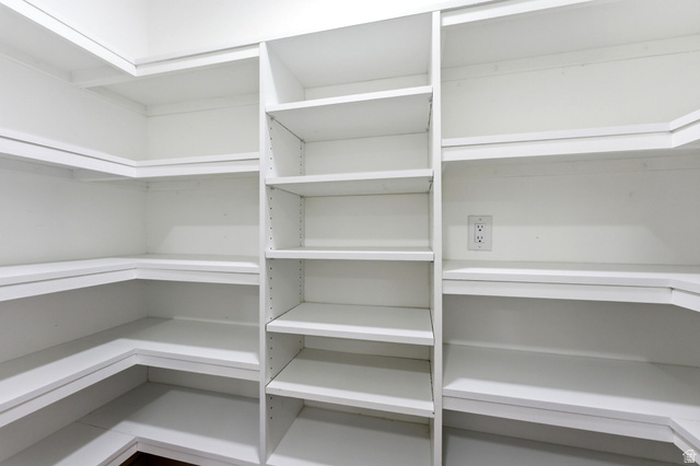 871 Bonita Way Centerville, UT 84014 - Photo 13 of 61 Walk-in pantry featuring expansive white shelving, L-shaped lower shelving, adjustable vertical shelving, and wall outlets