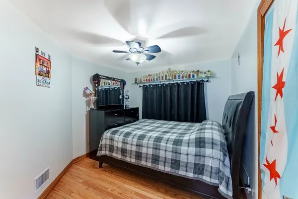 a bedroom with a bed and a flat tv screen on the dresser