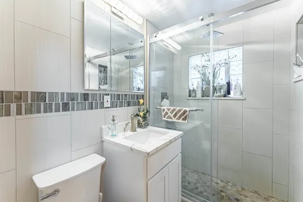 a bathroom with a sink a toilet and shower