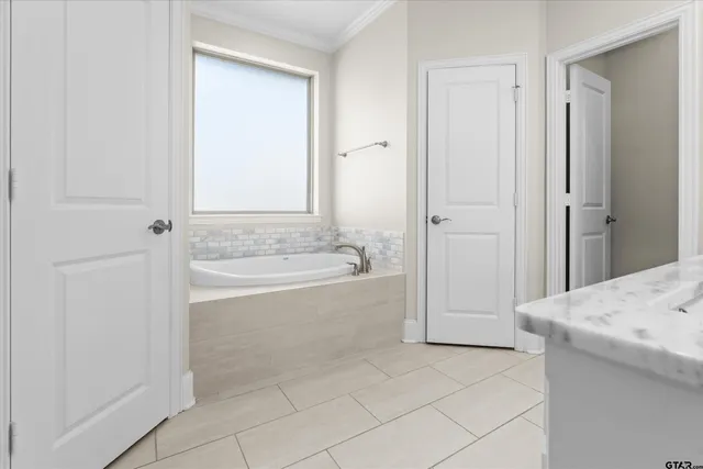 a spacious bathroom with a tub shower and a sink