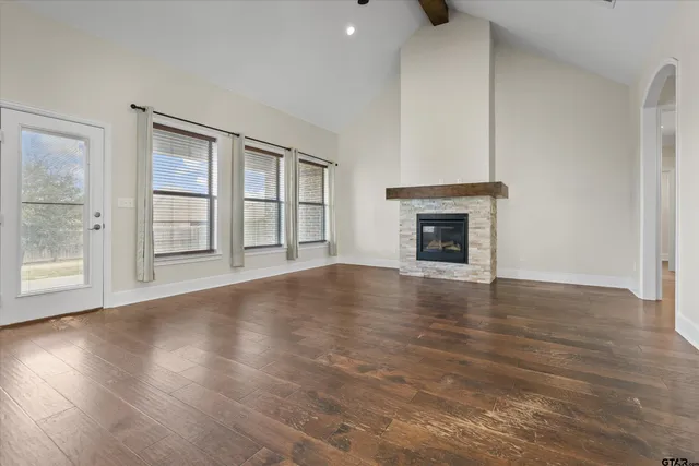 wooden floor fireplace and windows in an empty room