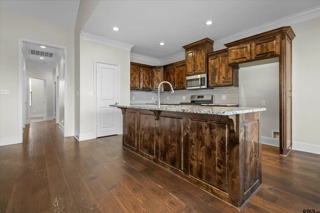 a kitchen with stainless steel appliances granite countertop a sink and a refrigerator