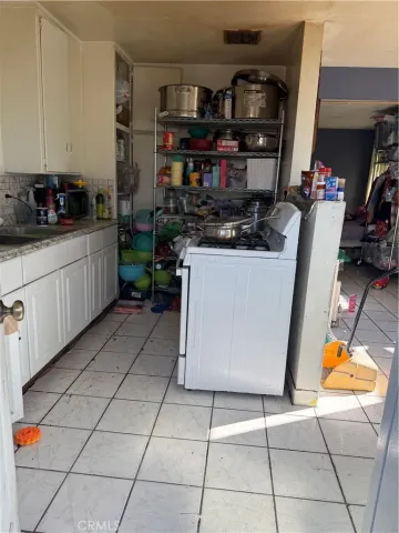 a kitchen with stainless steel appliances granite countertop a sink a stove and white cabinets
