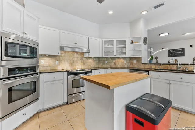 a kitchen with granite countertop a sink and chairs