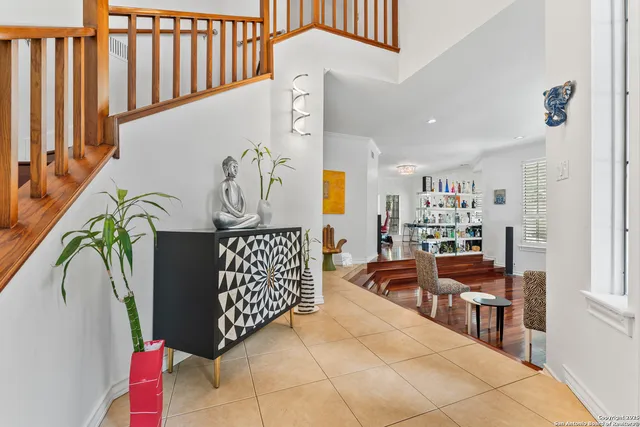 a dining room with wooden floor a chandelier a wooden table and chairs