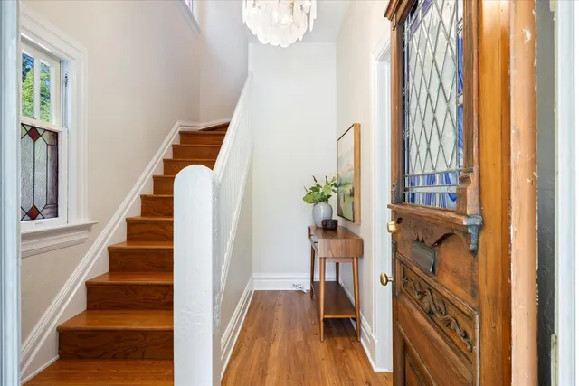 a view of a hallway with wooden floor and staircase