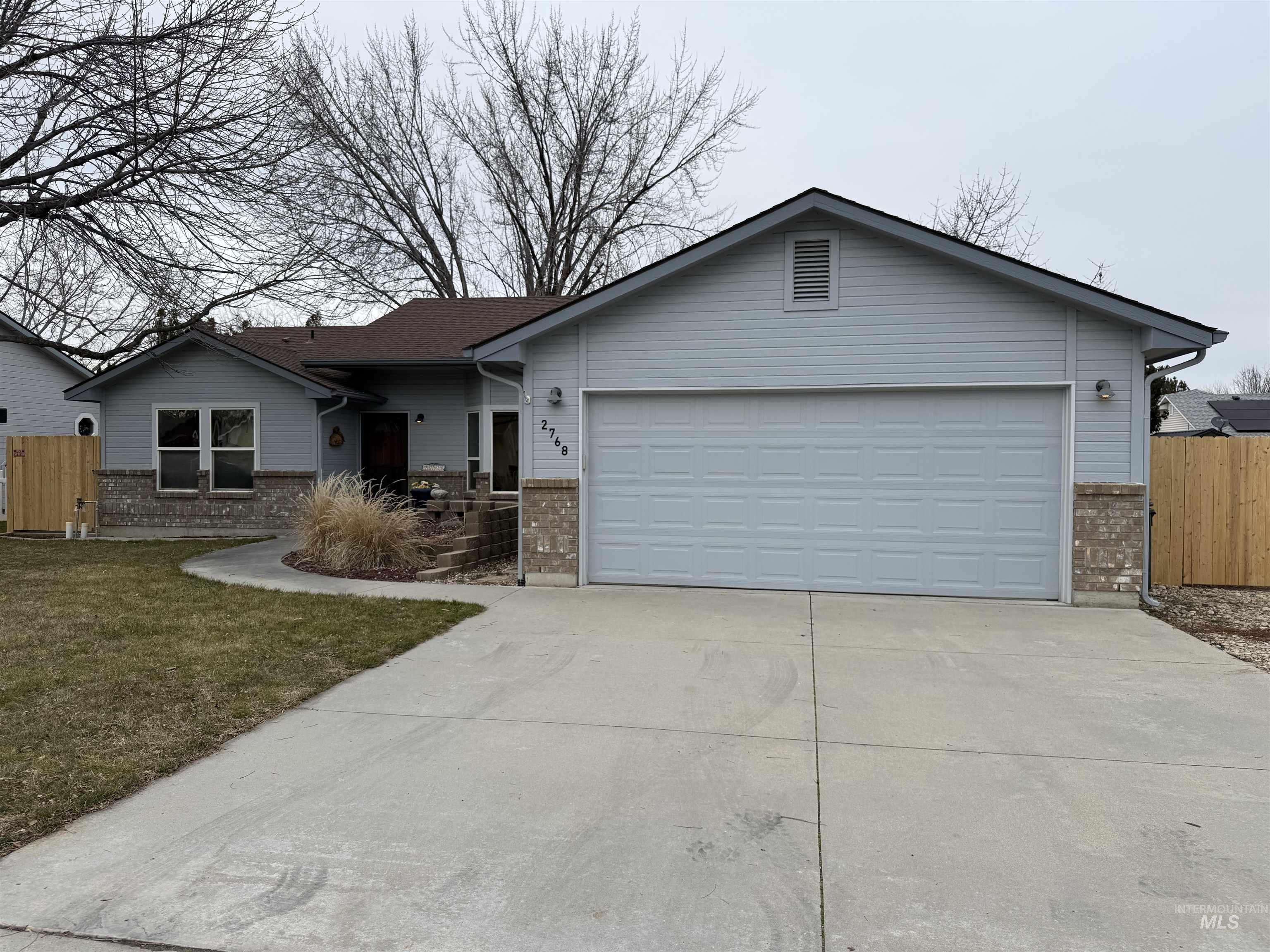 Ranch-style home featuring brick siding, concrete driveway, and a garage