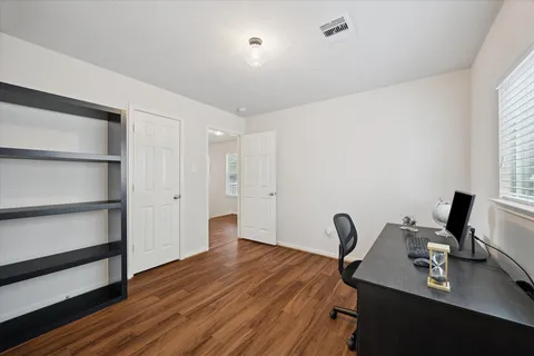 a view of workspace with wooden floor windows