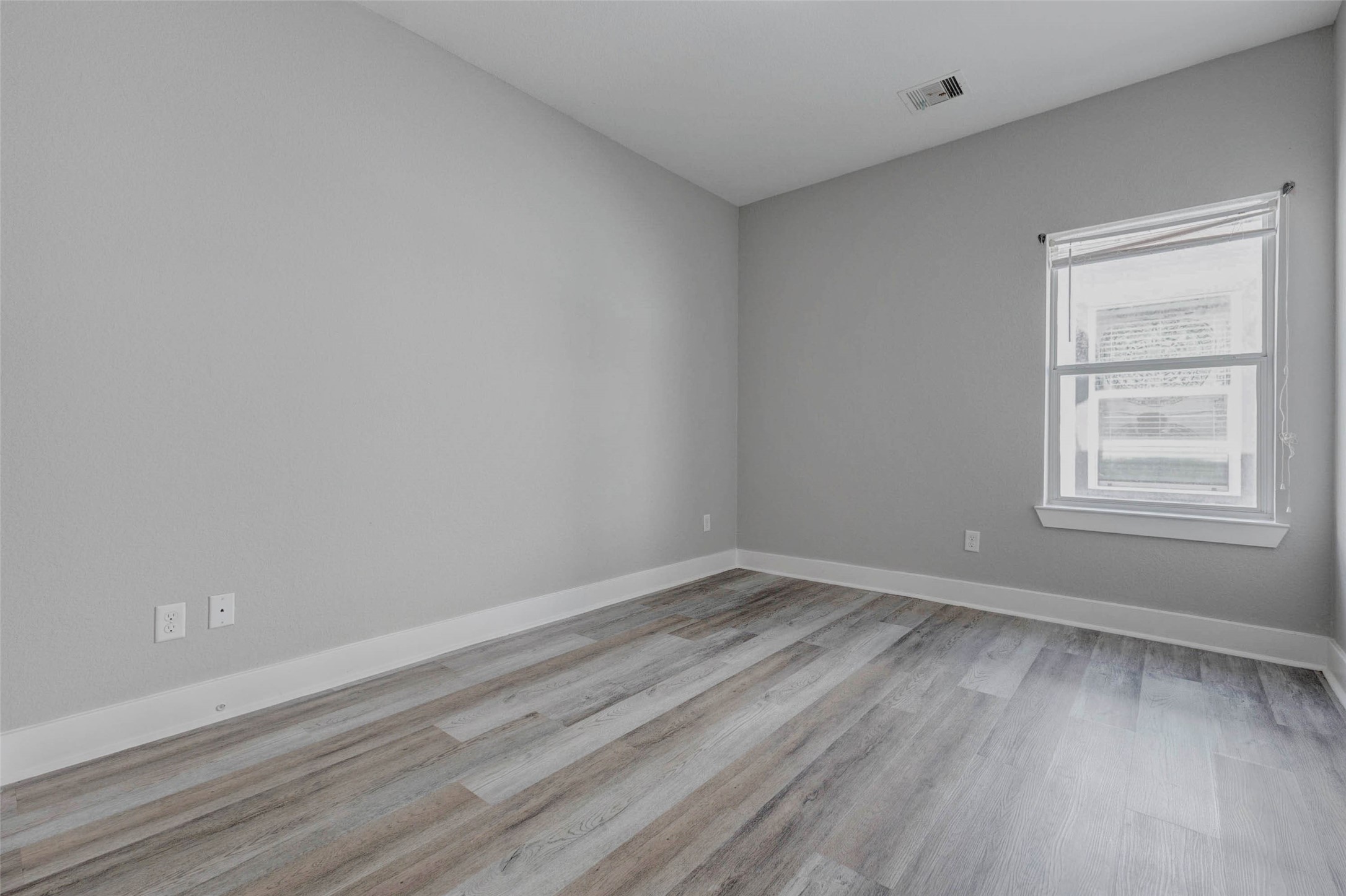 4834 Hollow Hook Road, Unit A Houston, TX 77041 - Photo 21 of 30 a view of an empty room with wooden floor and a window