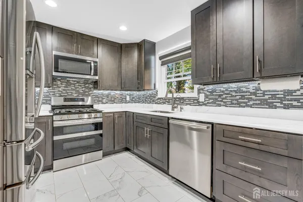 a kitchen with stainless steel appliances granite countertop a sink and cabinets