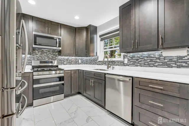 a kitchen with stainless steel appliances granite countertop a sink and cabinets