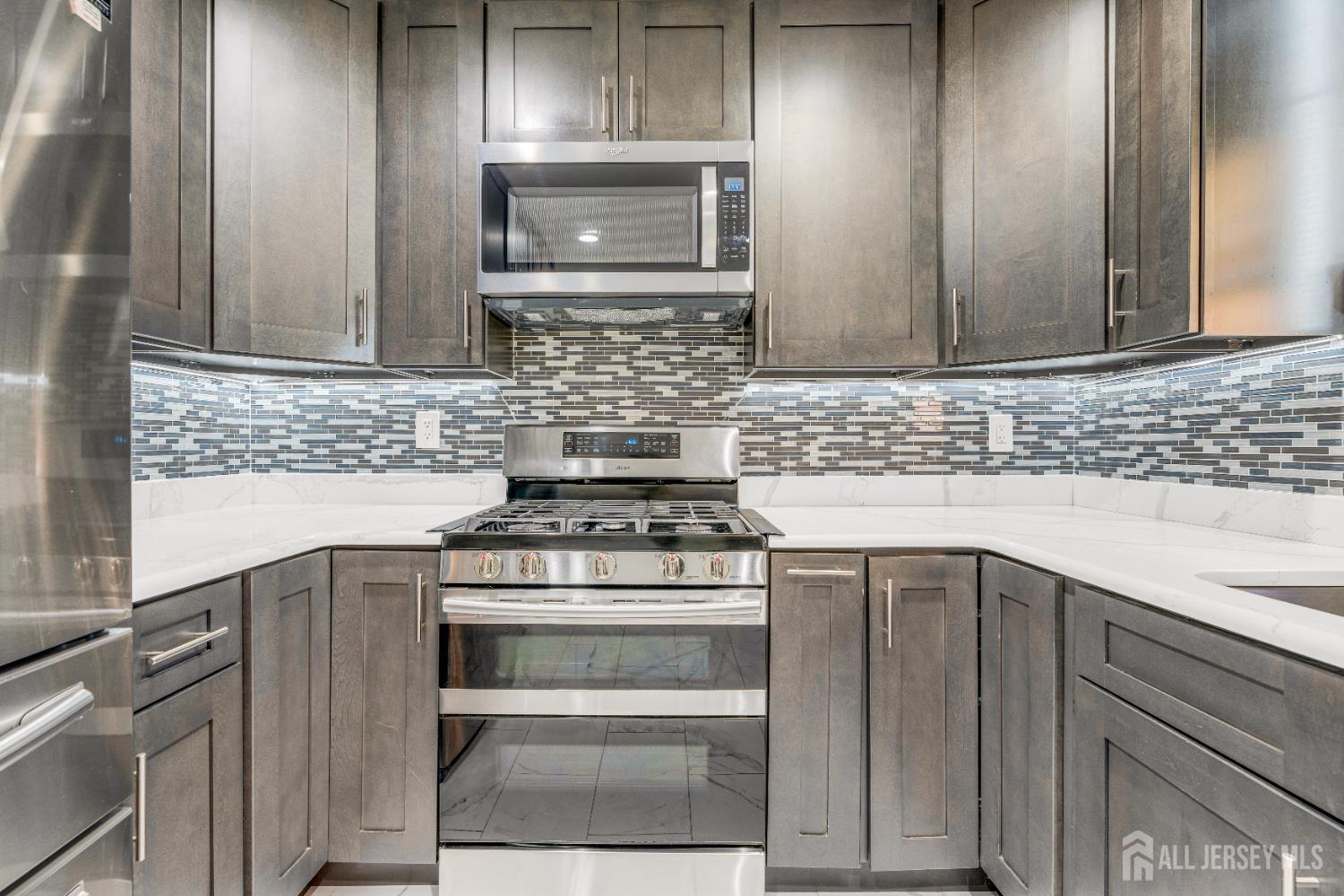 83 Pheasant Run Edison, NJ 08820 - Photo 13 of 38 a kitchen with a stove microwave and sink