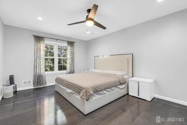 a bed sitting in a spacious bedroom next to a window