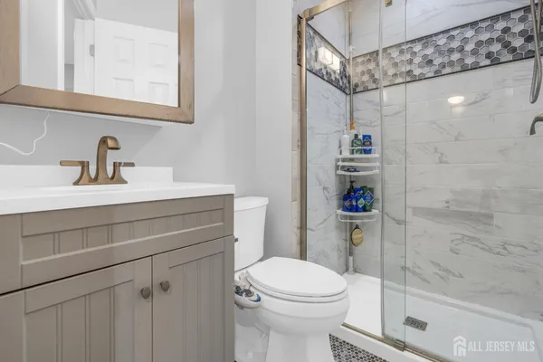 a bathroom with a sink a toilet and shower