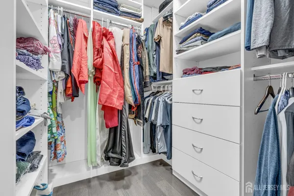 a view of walk in closet with clothes and shoes