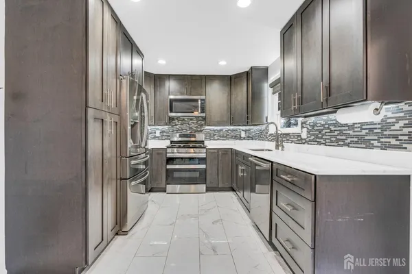a kitchen with stainless steel appliances a sink stove and refrigerator