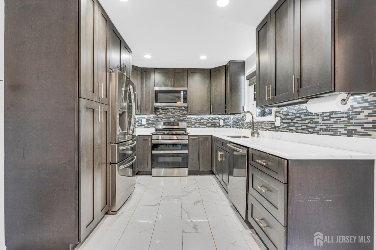 83 Pheasant Run Edison, NJ 08820 - Photo 10 of 38 a kitchen with stainless steel appliances a sink stove and refrigerator