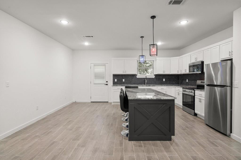 6771 Northwest County Road 1146 Barry, TX 75102 - Photo 9 of 34 a kitchen with kitchen island a sink stainless steel appliances and cabinets