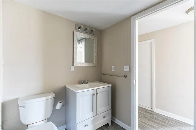 a bathroom with a toilet sink and mirror