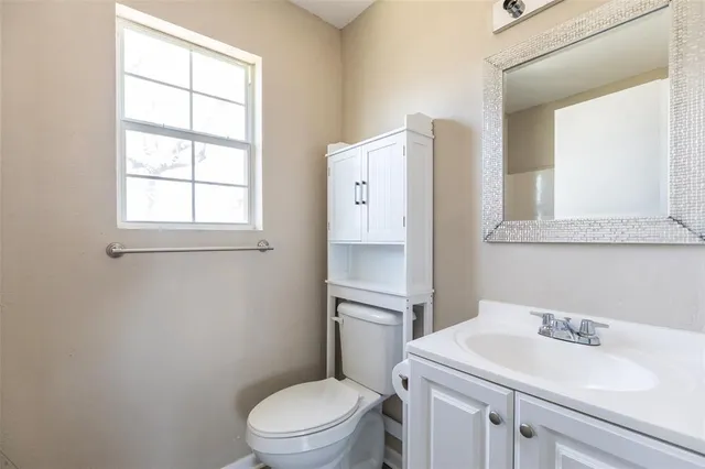 a bathroom with a toilet a sink and a window
