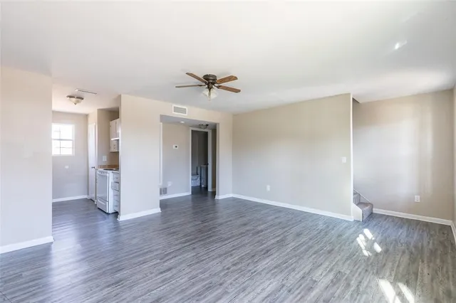 a view of a livingroom with wooden floor and a kitchen
