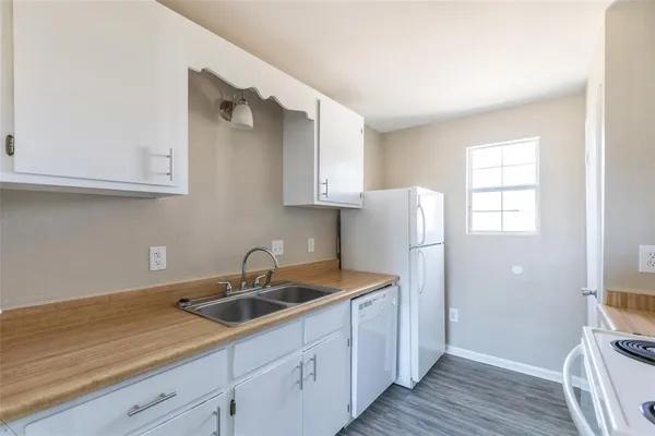 a kitchen with a sink cabinets and wooden floor