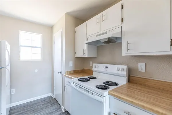 a kitchen with white cabinets stove top oven and sink
