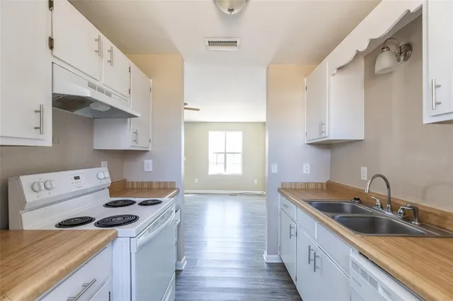 a kitchen with stainless steel appliances a sink a stove and a refrigerator