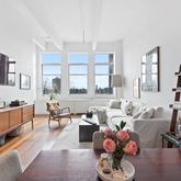 a living room with furniture fireplace and a large window