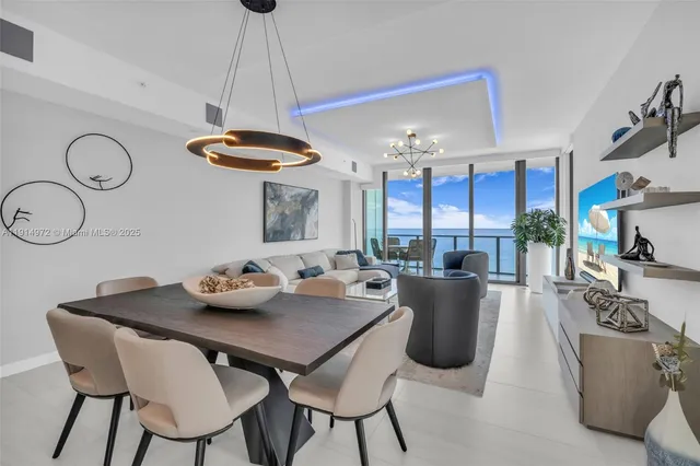 a view of a dining room with furniture a chandelier and wooden floor