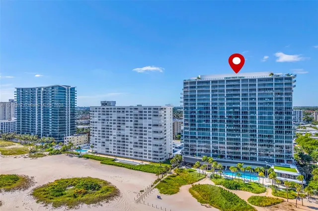 a view of a swimming pool with a lawn chairs and palm tree