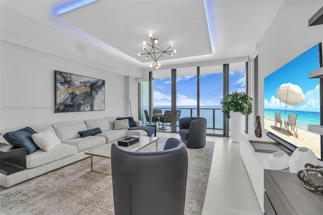 a living room with furniture potted plant and a large window