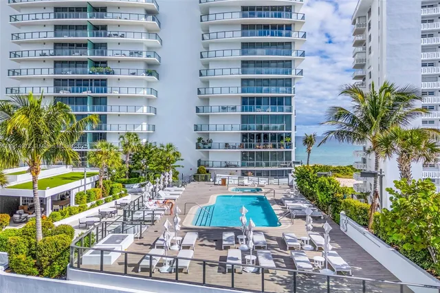 a view of a dining room with furniture one side kitchen view and wooden floor