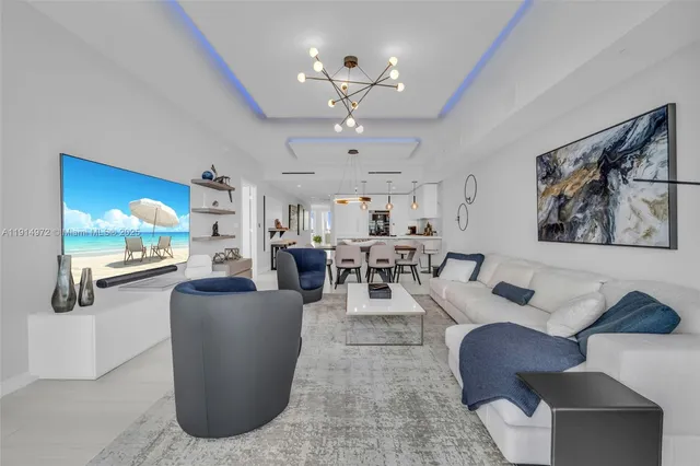 a living room with furniture a chandelier and a flat screen tv