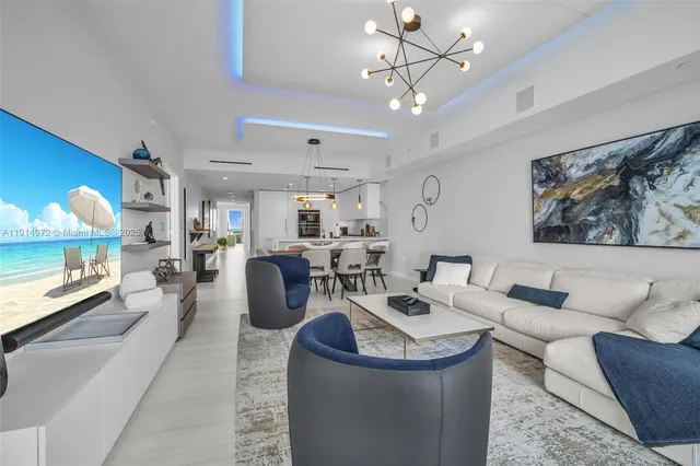 a living room with furniture a chandelier and a mirror