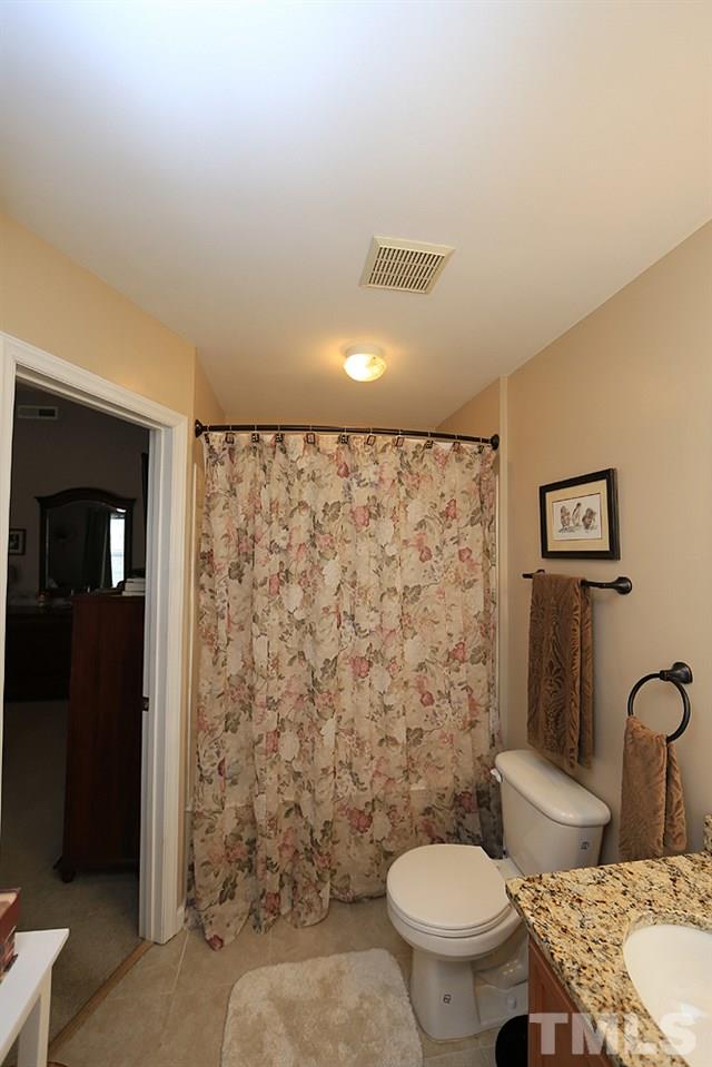 2111 Piney Brook Road, Unit 107 Raleigh, NC 27614 - Photo 13 of 23 a bathroom with a granite countertop toilet and a sink