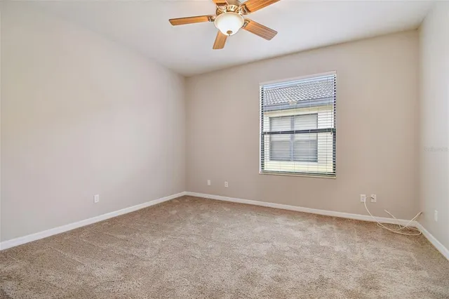 an empty room with chandelier fan