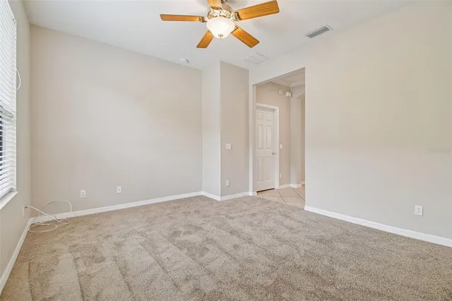 an empty room with closet and a chandelier fan