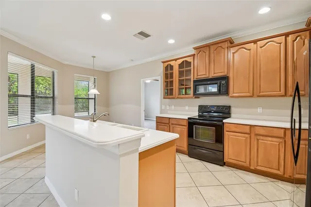 a kitchen with stainless steel appliances granite countertop a stove a sink and a microwave