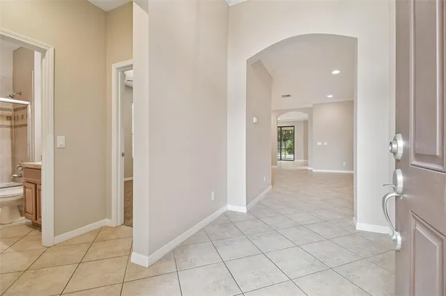 a view of a hallway with wooden floor and a bathroom