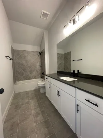 an empty room with a window and chandelier fan