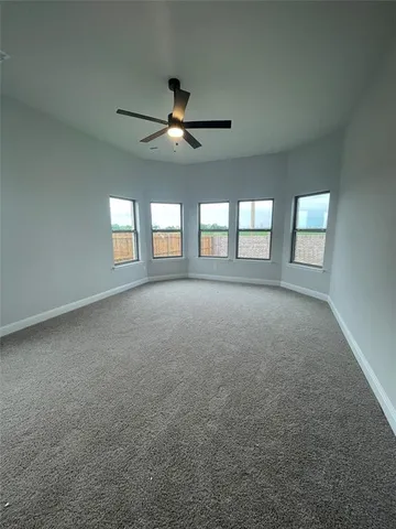 an empty room with wooden floor fireplace and windows