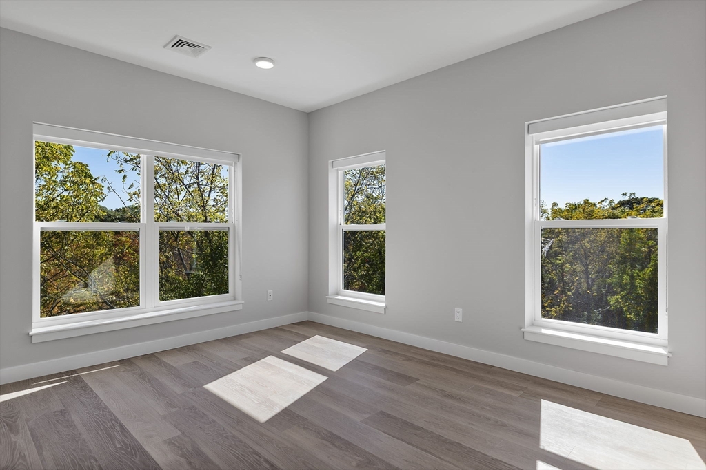 59 Mill Street, Unit 106 Woburn, MA 01801 - Photo 1 of 18 a view of an empty room with wooden floor and a window
