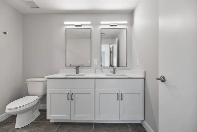 a bathroom with a toilet a sink and mirror
