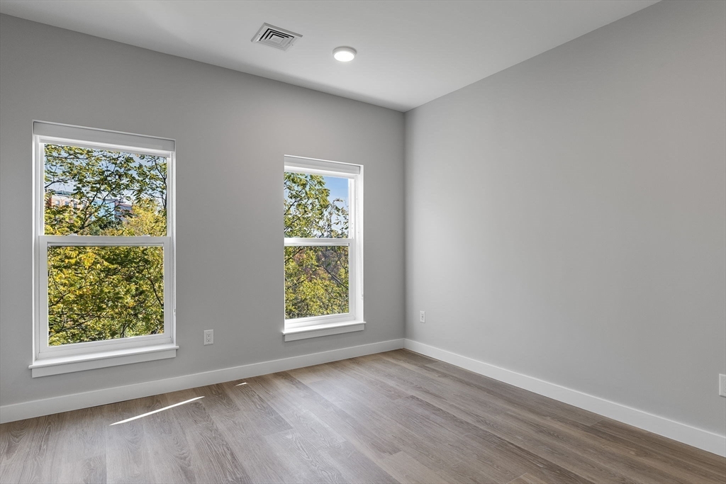59 Mill Street, Unit 106 Woburn, MA 01801 - Photo 18 of 18 an empty room with wooden floor and windows
