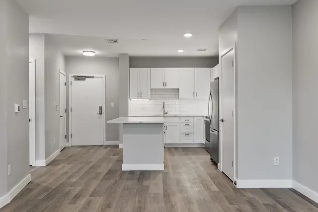 a kitchen with white cabinets and stainless steel appliances