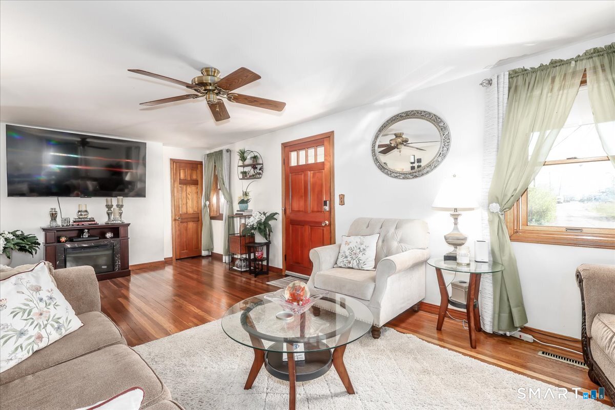 306 Welton Street Hamden, CT 06517 - Photo 6 of 38 a living room with furniture a flat screen tv and kitchen view